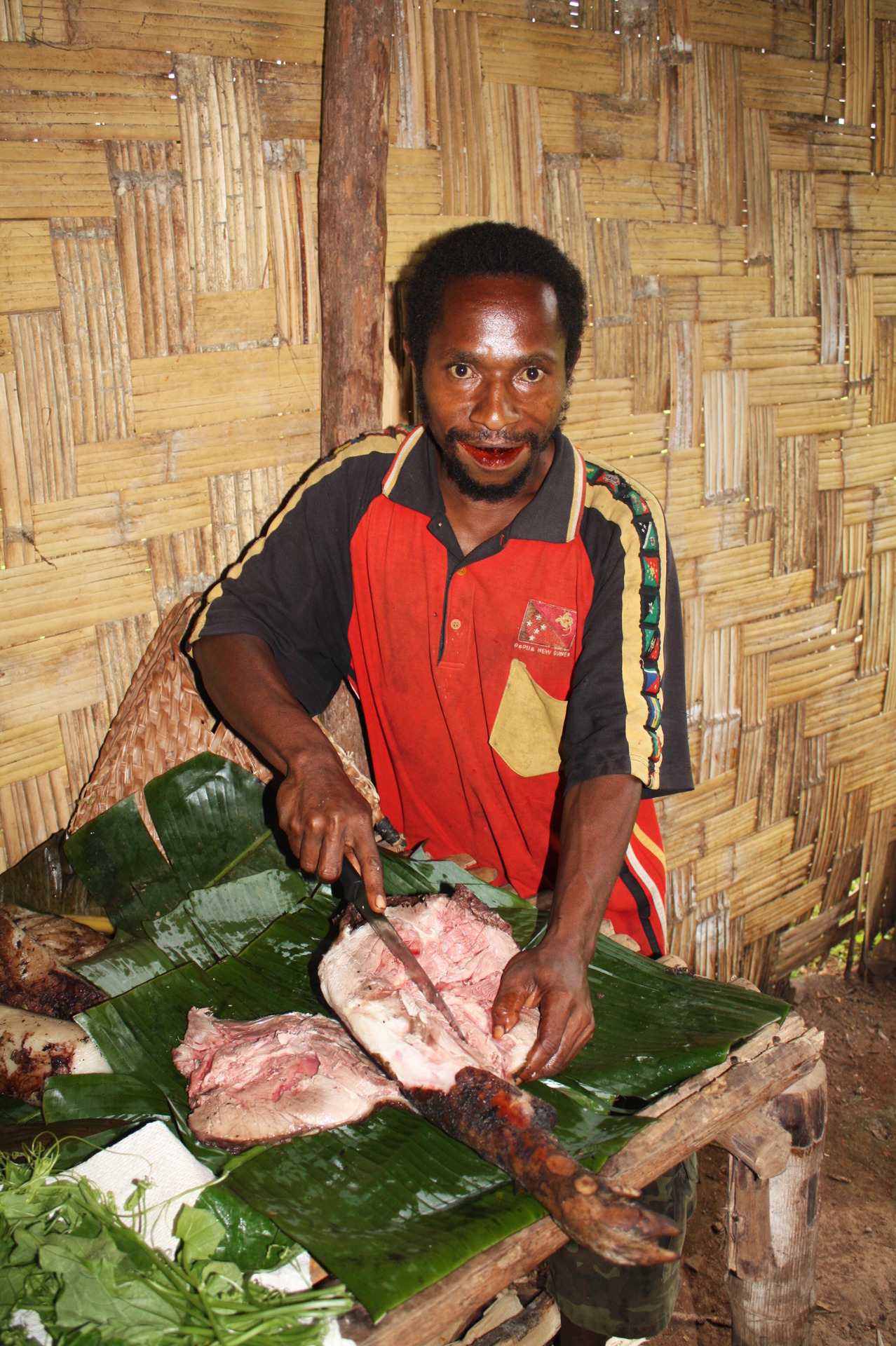 Peter ( náš kuchař) připravující prasátko k večeři, Papua Nová Guinea