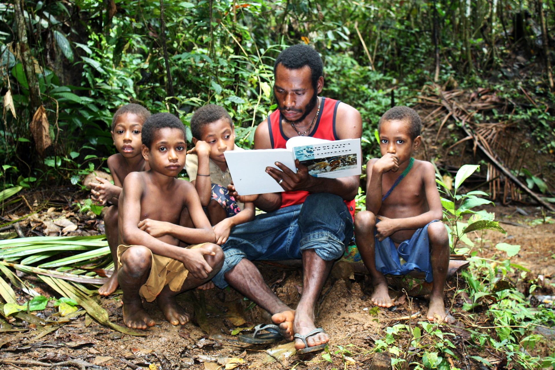 Vesnický učitel a děti – zaujati mou knihou, Papua Nová Guinea