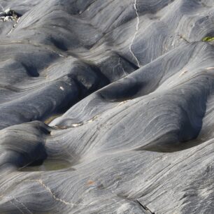 Sopečný povrch na jedné z pláží ostrova