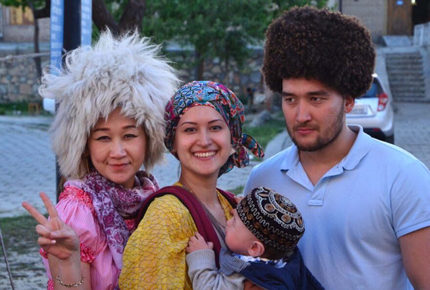 Rodinka na bazaru v bucharském starém městě, kde možno vyzkoušet všechny druhy beraních čepic