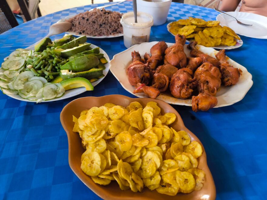 Tradiční kubánský oběd nebo večeře – kuřecí paličky s přílohou (smažené chipsy „Chichato“, rýže „Arróz congri“) a salátem