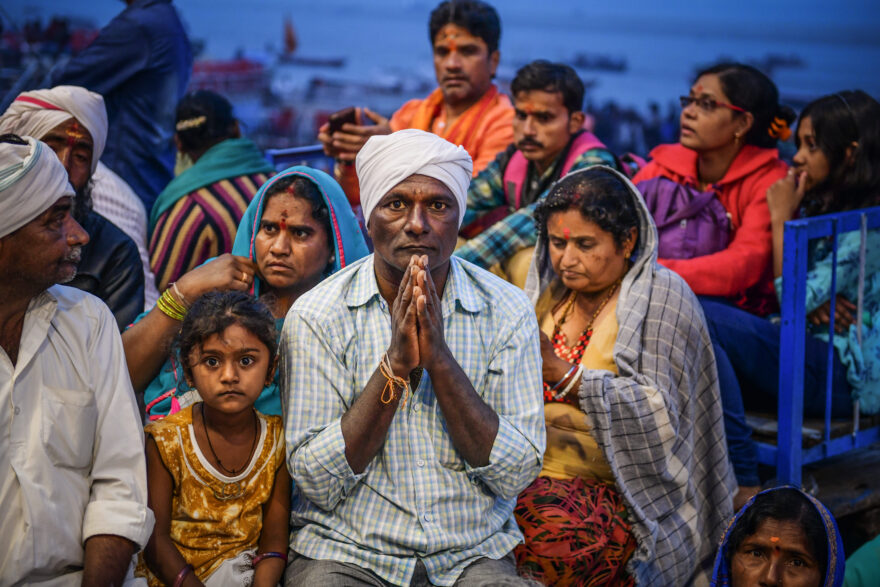 Poutníci během večerní modlitby u Gangy