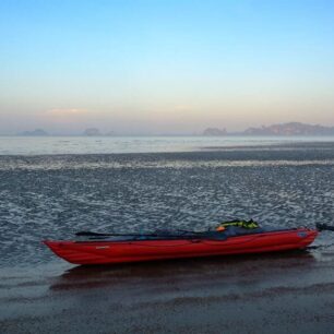 Svítá, je bezvětří, optimální čas vyrazit na další cestu. Ještě ale vytáhnout kajak desítky metrů přes blátivé mělčiny na vodu.