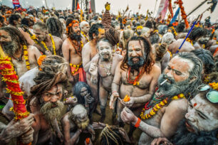 Sádhuové se řadí do zástupu, který z obou stran obklopují indičtí policisté s dřevěnými holemi v rukou, aby razili cestu a rozháněli davy přihlížejících. Průvod se dává do pohybu. Občas zastaví, a to je vhodná chvíle na pokouření. Nágové zapalují své hliněné fajfky čilamy napěchované tabákem, někdy i marihuanou či hašišem. Jsou to asketi, kteří se zřekli sexu, rodinného života i alkoholu, ale kouření ne. Je prý božského původu a propojuje je s jejich bohy.