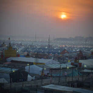 Půlnoc se rychle přehoupne a Nágové se začínají scházet. Atmosféra je plná napětí. Z reproduktorů všude kolem se linou rozskřípané hinduistické mantry, do očí štípe kouř z ohňů, které hoří všude kolem. Když foukne vítr, zvíří jemný písek z vyschlých břehů Gangy.