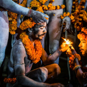 Je 10 °C nad nulou – někteří naháči se klepou zimou, jiní jsou otužilí ze svých himálajských pousteven a snášejí zimu se stoickým klidem. Každou chvíli začne některý z nich křičet „Haré Haré“ a zdraví Kršnu a další hinduistická božstva. Ostatní se přidávají. Je cítit jejich euforie a nedočkavost, až dorazí k Matce řek a vrhnou se do jejích očistných vod, aby ze sebe smyli vše špatné.