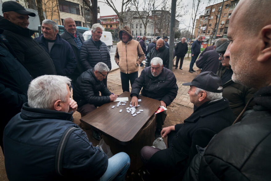 Albánští muži hrají na ulici domino. Je to poměrně častý obrázek. Všimněte si pestrobarevných místních krojů.