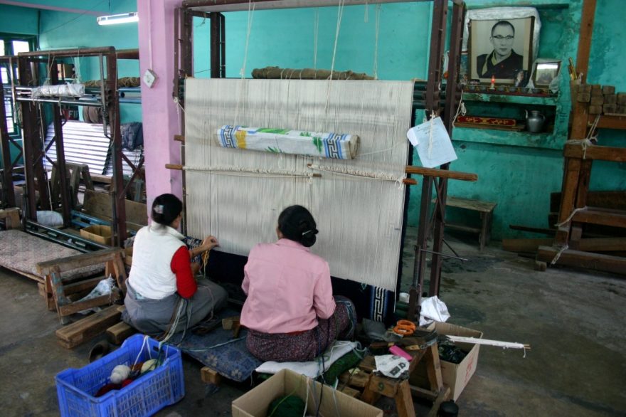 Tibetské ženy pod dohledem Dalajlámy pracují v továrně na výrobu tradičních koberců, Indie