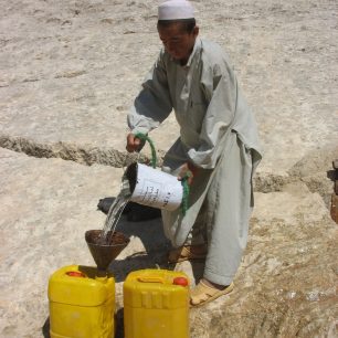 Chlapec nabírá vodu z kandázy, Zare, Afghánistán