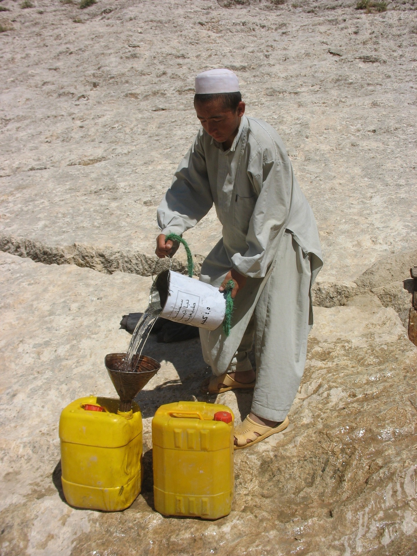 Chlapec nabírá vodu z kandázy, Zare, Afghánistán
