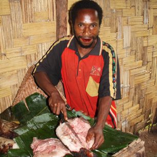 Peter ( náš kuchař) připravující prasátko k večeři, Papua Nová Guinea
