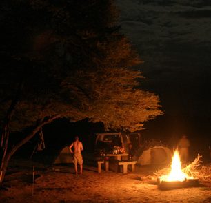 Noční oheň v kempu. Afrika. 