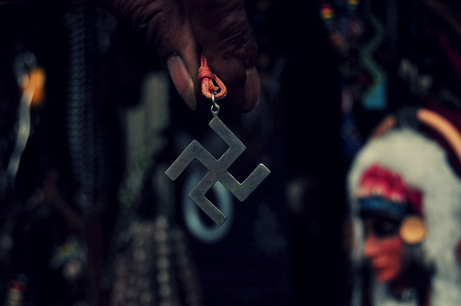 Pouliční  obchodníci nabízí přívěšky s pravotočivou svastikou