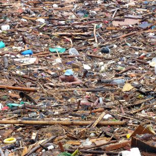 Filipíny. Chlapec uvízlý mezi naplaveninami. Chudí sbírají vše potřebné.