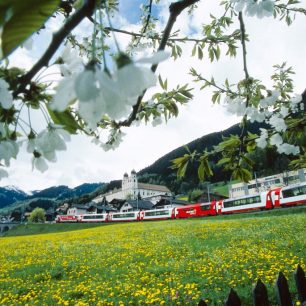 Vlak projíždí typickou krajinou, Švýcarsko
