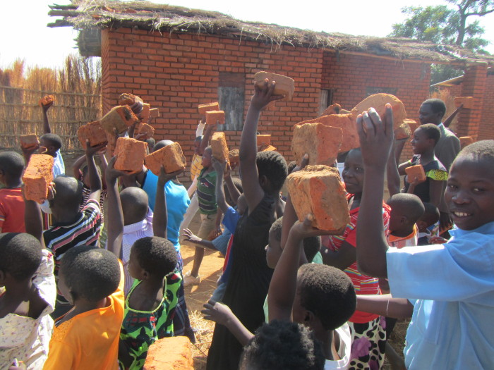 Lidé nesou cihly na stavbu nemocnice, Malawi