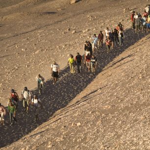 Zástup lidí kráčí na západ slunce v Měsíčním údolí v Chile