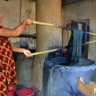 Nitě se máčejí ve vroucí barvě pomocí bambusových tyčí, Bangladéš