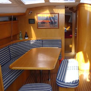 Fotografie znázorňuje interiér lodi. Jsou zde 2 koupelny 4 kajuty, celkem se tedy na loď vejde až 8 osob. Salón představuje společnou prostoru, kde se tráví volný čas. Vlevo vykukuje navigační stolek.
