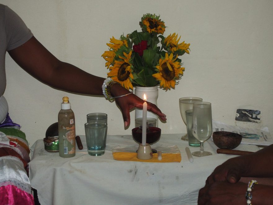 Skromný domácí oltář, např. sklenice vody slouží k napojení a pohoštění vyzývaných bohů, Kuba