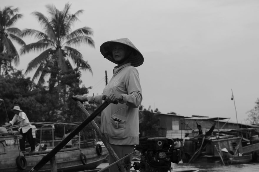 Jedna z žen prodávající ananasy na své lodi, plovoucí trhy, Can Tho, Vietnam