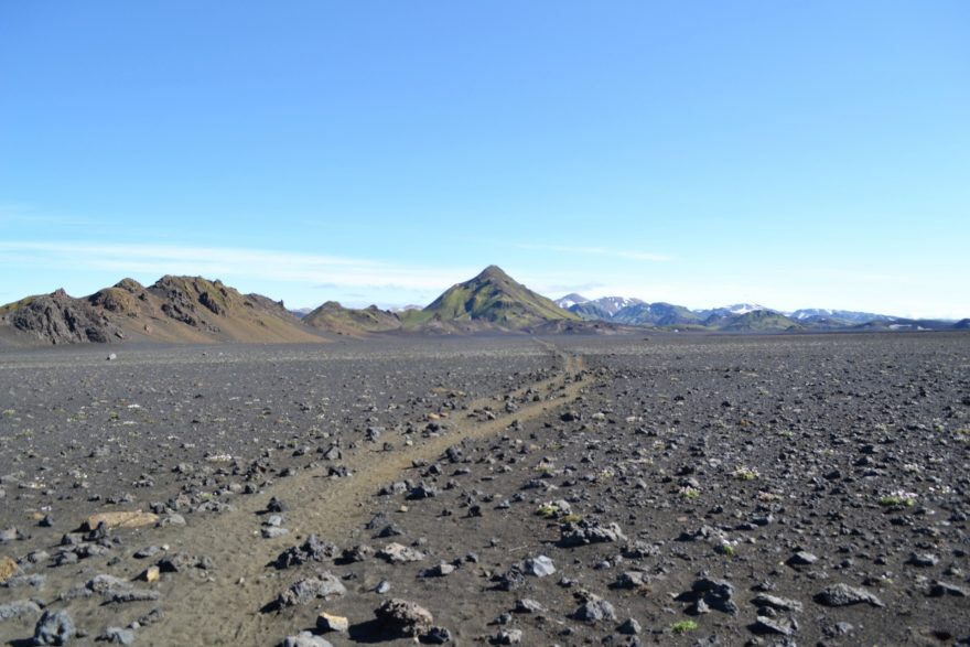 Cesta přes poušť sopečného popela. Roztroušené kamení prozrazuje, kam až dosáhl výbuch sopky Eyjafjallajökull v roce 2010, Island