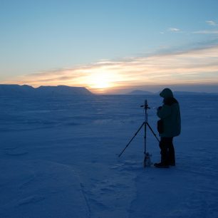 Petr Scheirich zapisuje každodenní meteorologické údaje. U nohy stativu s přístroji hlídací plyšák Shackelton. (Arctos 5, březen 2015)