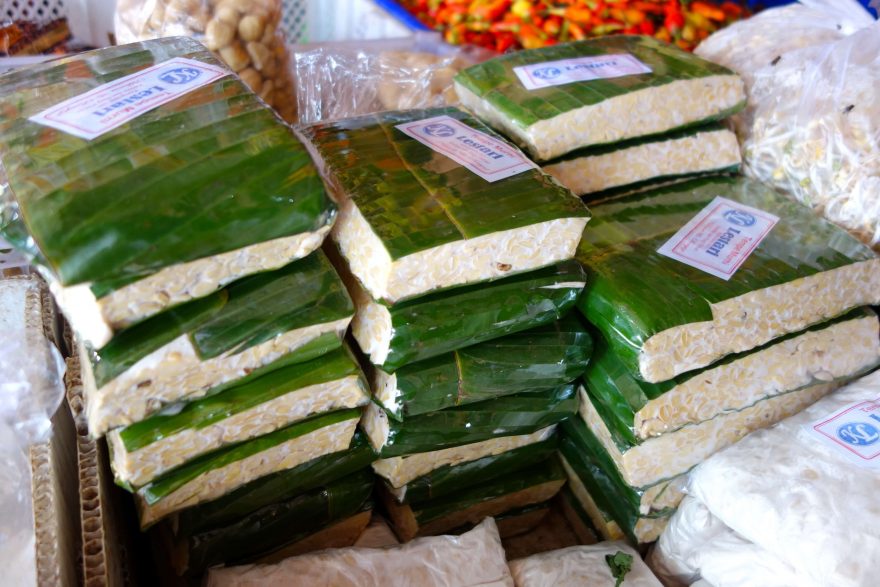 Prodej tempehu v banánových listech na tržišti v Indonésii