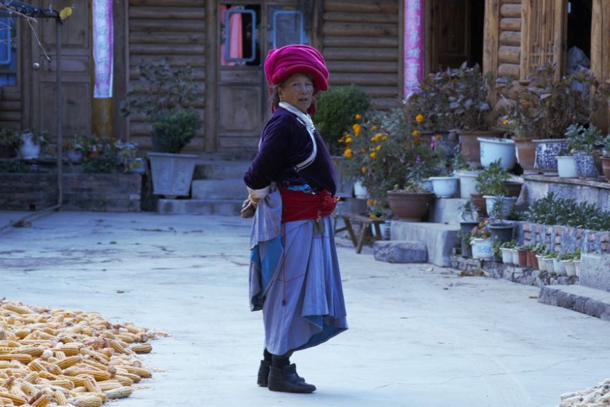 Žena z kmene Mosuo před svým domem
