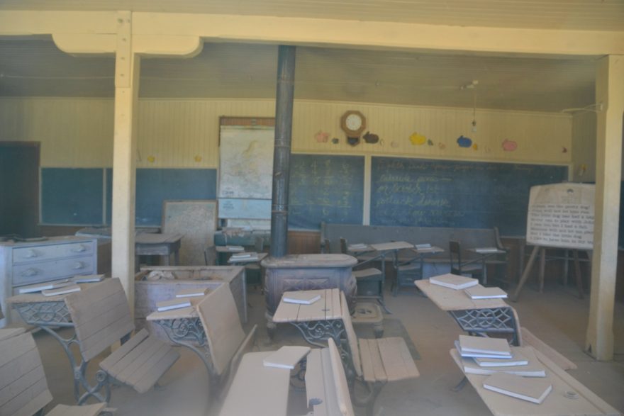 Ve škole zůstala kromě zaprášených lavic i nesmazaná tabule. Bodie, USA