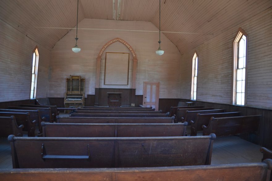 Vcházíme do prostě zařízeného kostela s řadami dřevěných lavic a skromným oltářem bez jediné ozdoby.