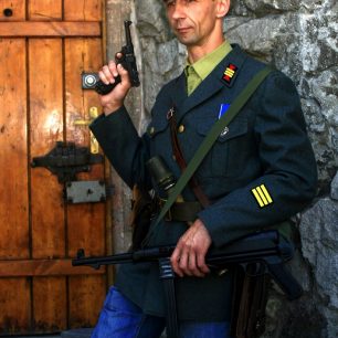 Svérázný hromotluk v uniformě se samopalem střeží vstup do Banderovské hospody