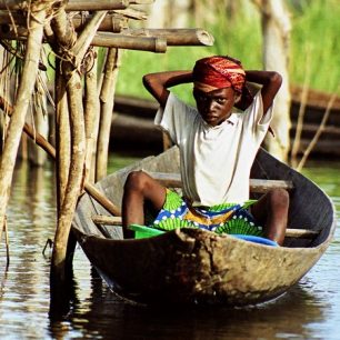 Ganvijský chlapec si uvazuje šátek před vyplutím za kamarády. 